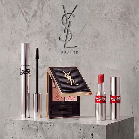 Flat-Lay von YSL Beauty-Produkten mit Parfum, Pflege und Make-up.