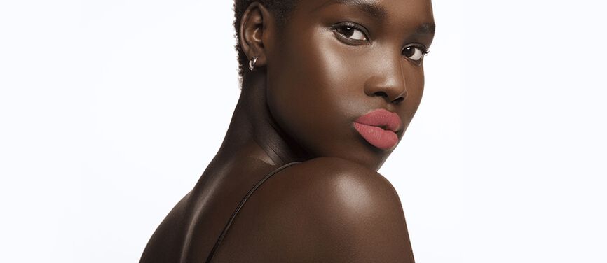Model wearing soft pink lipstick.