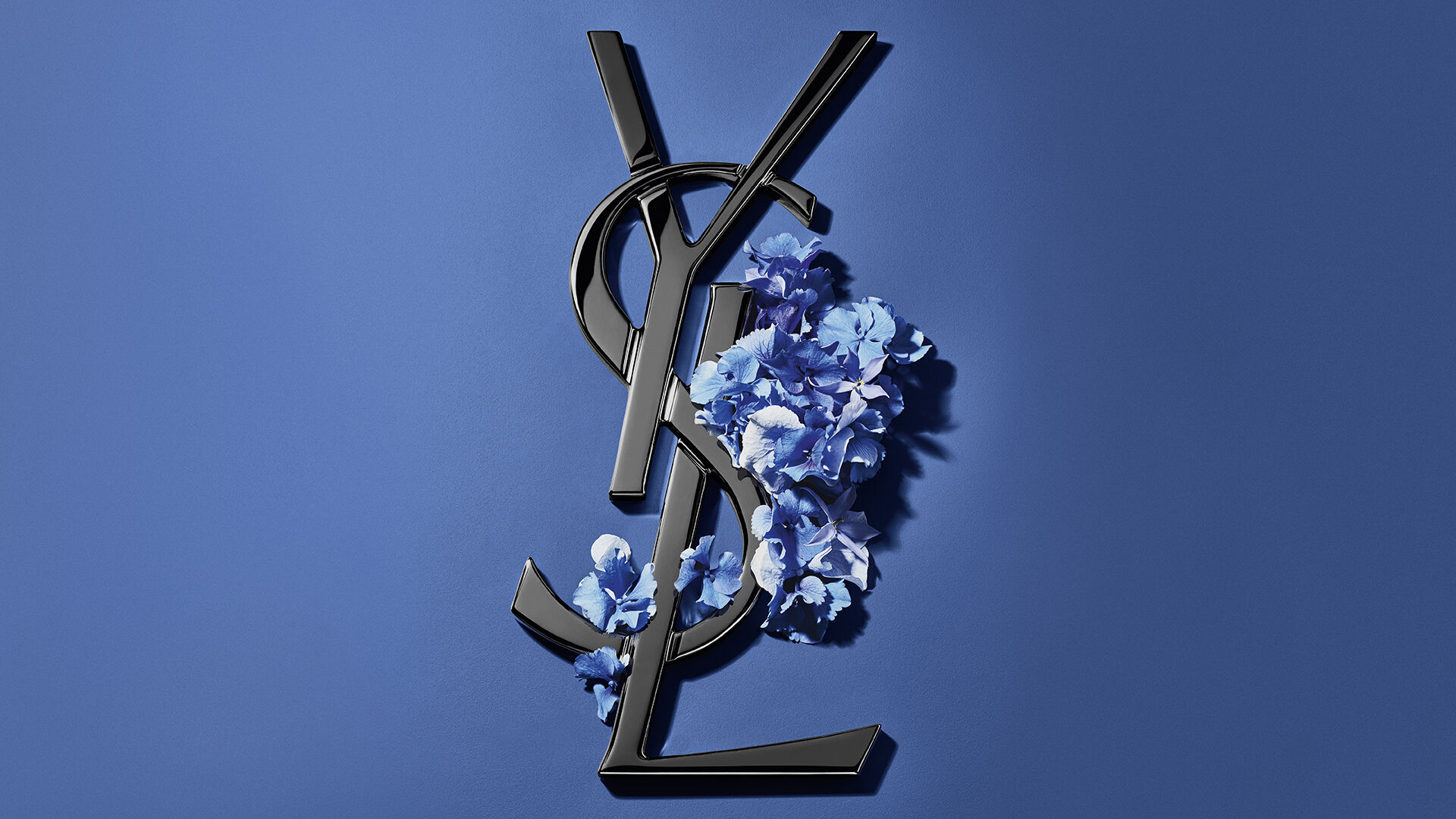 Blaue YSL-Geschenkbox mit Hortensien auf blauem Hintergrund.