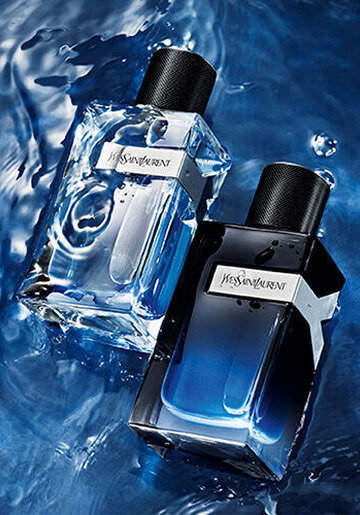 Two stylish perfume bottles resting on a shimmering blue water surface, one clear and the other dark, both showcasing a modern design.