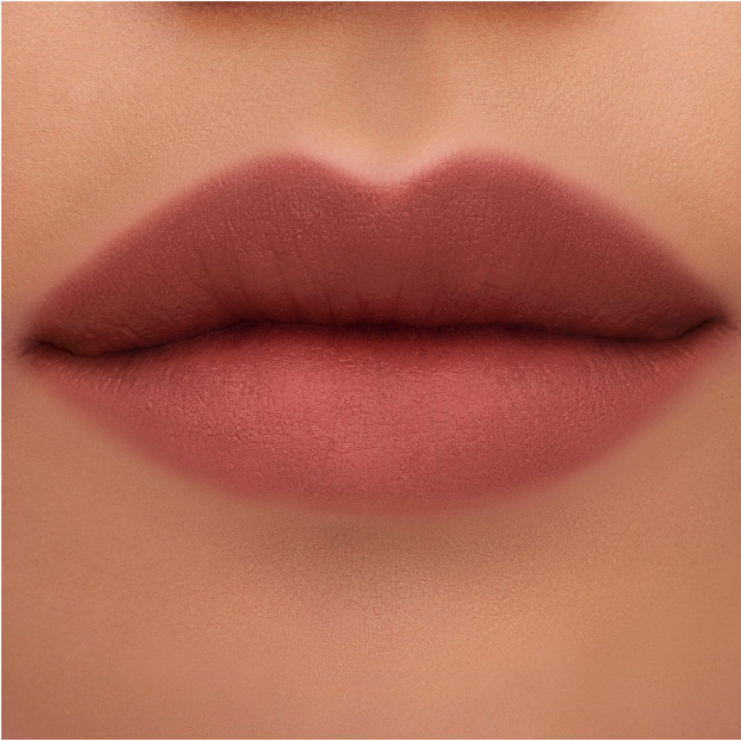 Close-up of a pair of smooth lips with a matte nude lipstick finish.