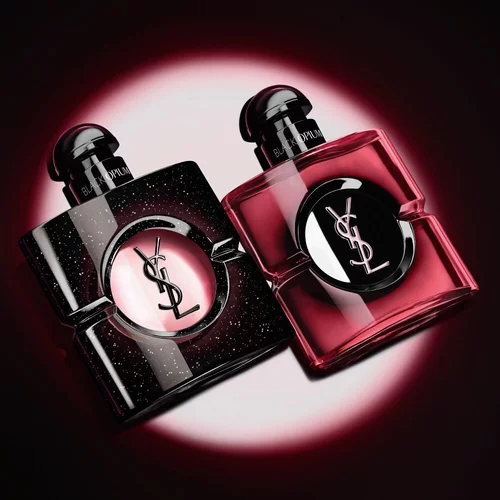 Zwei beleuchtete Yves Saint Laurent Black Opium Parfumflakons vor dunklem Hintergrund.