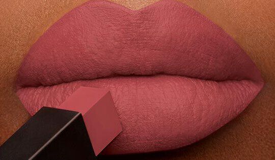 Close-up of lips applying a soft pink lipstick shade.