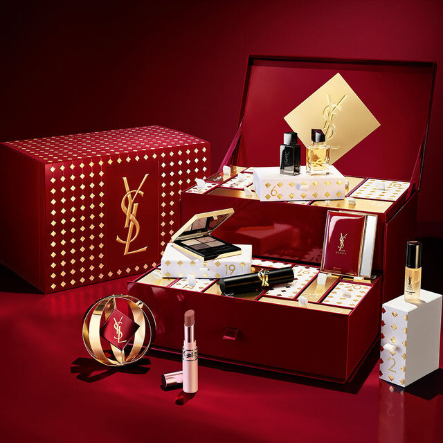 YSL-Adventskalender und Beauty-Produkte vor rotem Hintergrund.