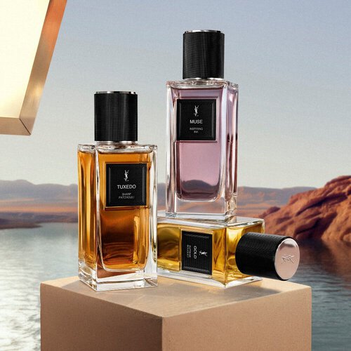 Flakons von YSL Le Vestiaire des Parfums auf einem Podest an einem Wustensee.