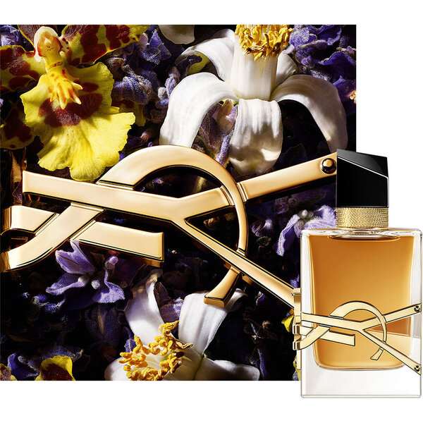 LIBRE EAU DE PARFUM INTENSE Flakon, umgeben von tiefvioletten Bluten und goldenen Kettendetails.