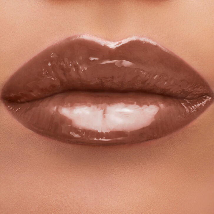 Close-up of glossy, nude-colored lips.