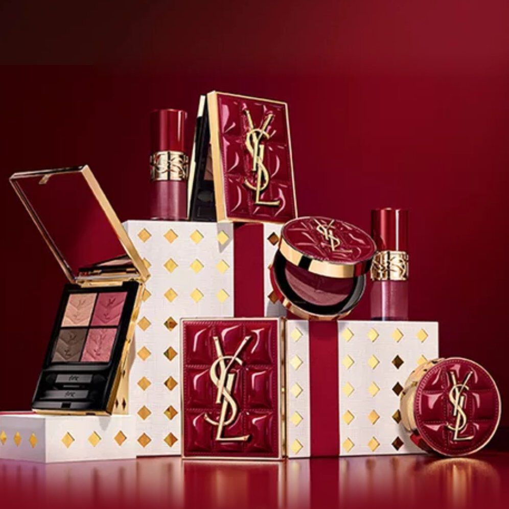 Yves Saint Laurent Weihnachtskollektion-Geschenksets und Luxus-Beautyprodukte vor festlich rotem Hintergrund.