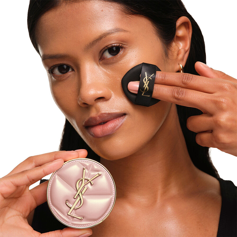 Model mit glatter, strahlender Haut, die das pinke YSL SKIN AFFAIR CUSHION FOUNDATION prasentiert und einen naturlichen, makellosen Glow zeigt.