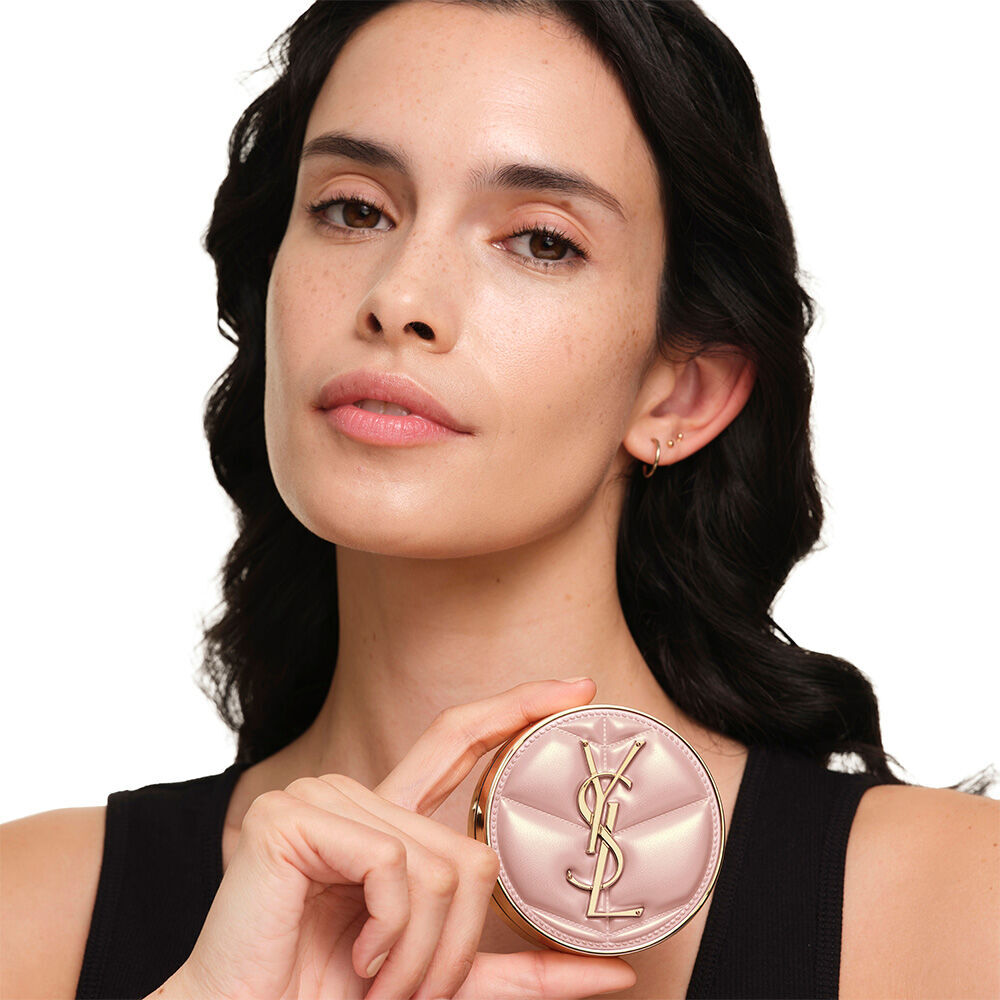 Model mit glatter, strahlender Haut, die das pinke YSL SKIN AFFAIR CUSHION FOUNDATION prasentiert – fur einen naturlich leuchtenden, makellosen Teint.