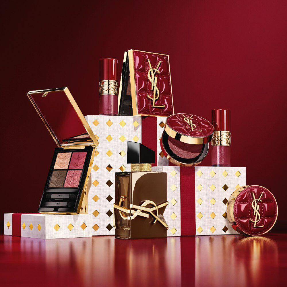 YSL Beauty Weihnachtssaison 2026 Make-up-Kollektion und Duft-Set auf goldgepunkteten weißen Sockeln in Burgund.