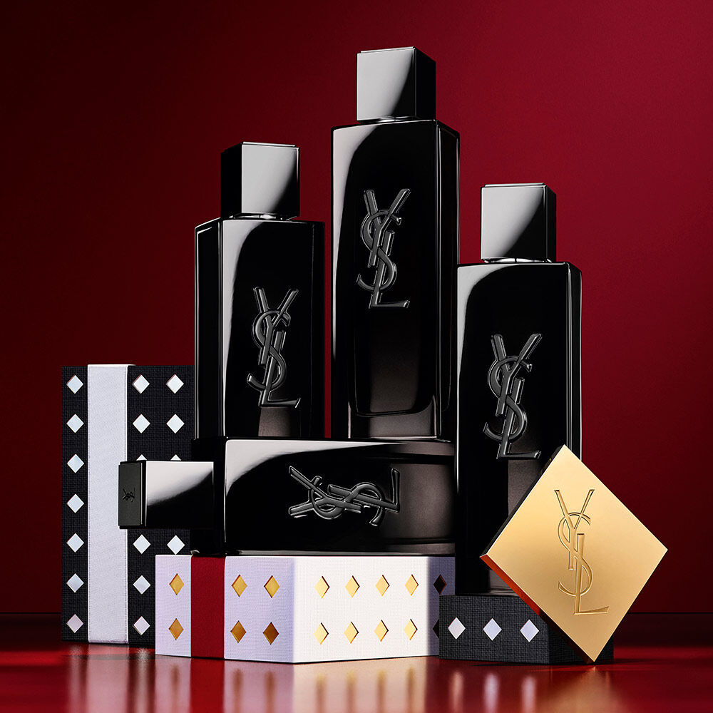 YSL MYSLF Eau de Parfum-Flakons, gestapelt auf schwarzen und silbernen gemusterten Holiday-Geschenkboxen.