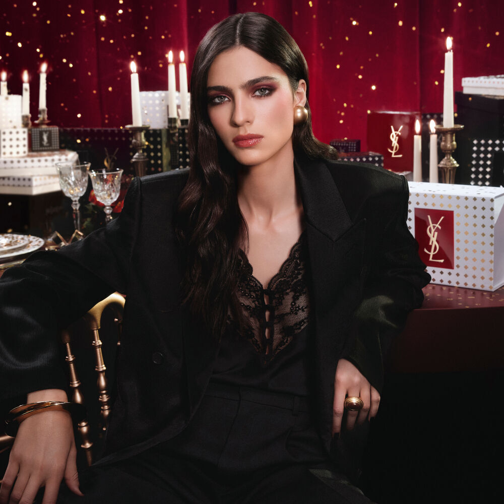Modell in schwarzem Anzug und glamourosem Look, sitzend in festlicher, kerzenbeleuchteter Atmosphare mit YSL-Geschenkboxen. Modell in schwarzem Anzug und glamourosem Look, sitzend in festlicher, kerzenbeleuchteter Atmosphare mit YSL-Geschenkboxen. Modell in schwarzem Anzug und glamourosem Look, sitzend in festlicher, kerzenbeleuchteter Atmosphare mit YSL-Geschenkboxen. B7Banner versteckt.