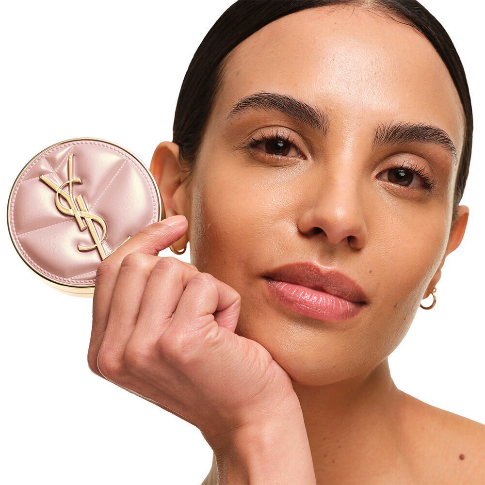Model mit glatter, strahlender Haut halt das pinke YSL SKIN AFFAIR CUSHION FOUNDATION, um einen naturlichen, makellosen Glow zu prasentieren.
