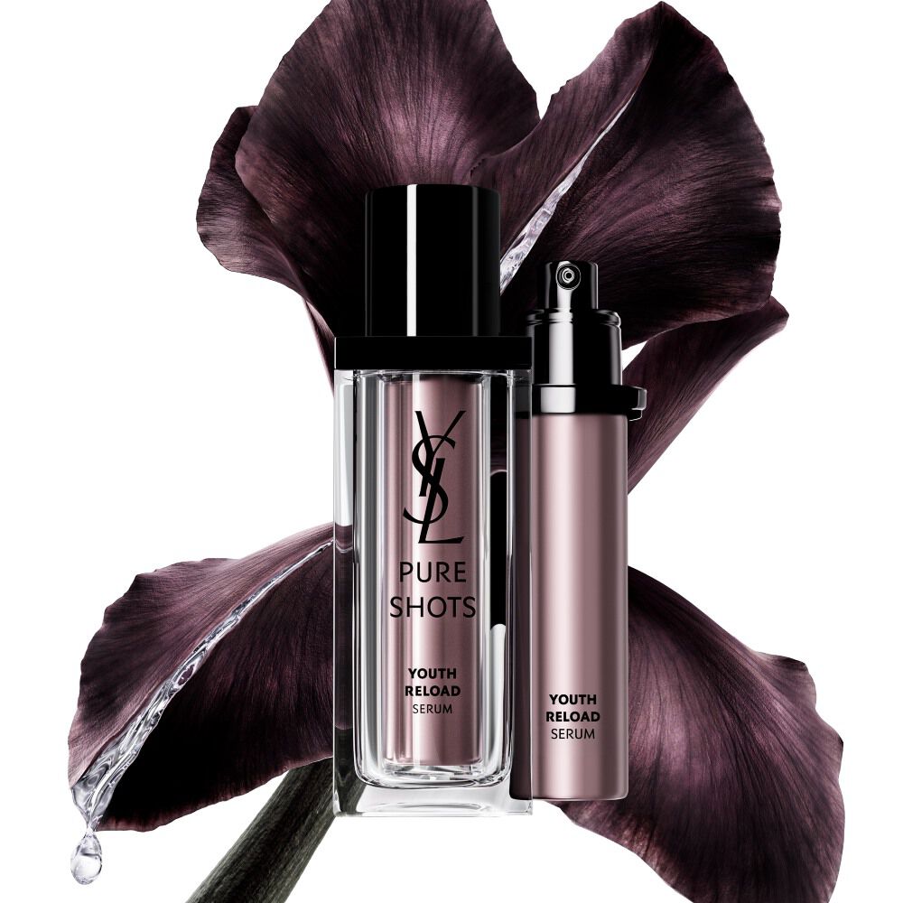 YSL Beauty Pure Shots Youth Reload Serum und seine nachhaltige Nachfüllpackung, präsentiert vor einer dunkelvioletten Irisblüte.