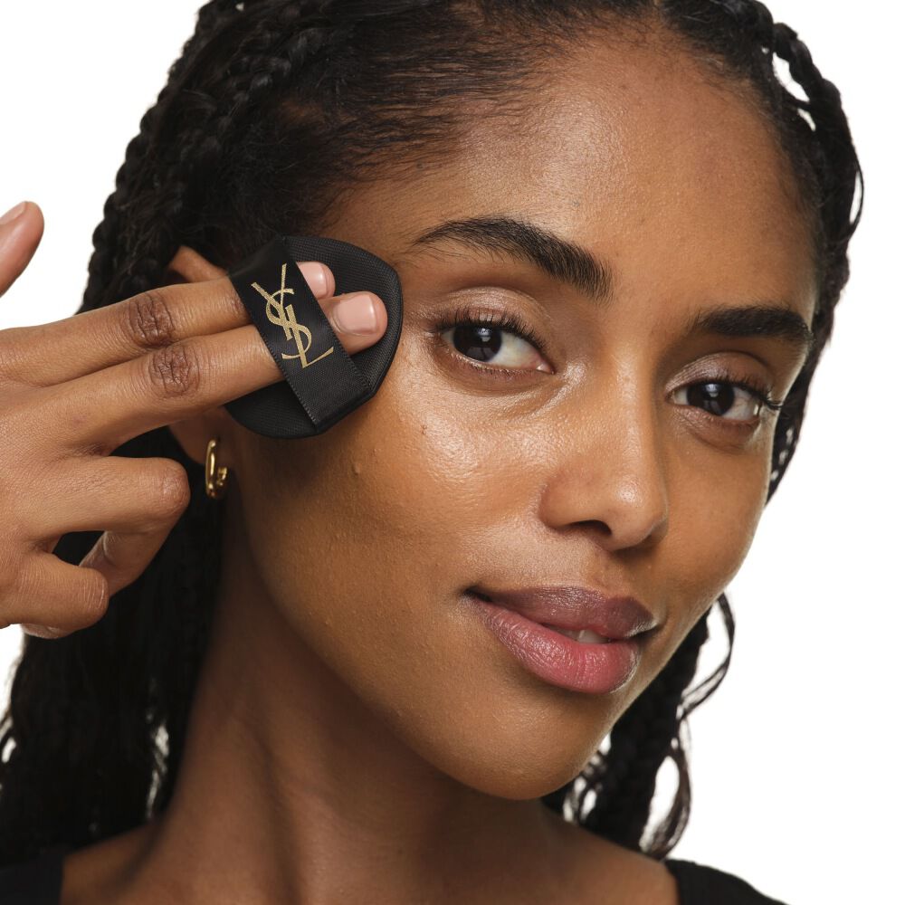 Nahaufnahme zeigt, wie man das YSL SKIN AFFAIR CUSHION auf die Wange tupft für einen nahtlosen, aufbaubaren und strahlenden Auftrag.