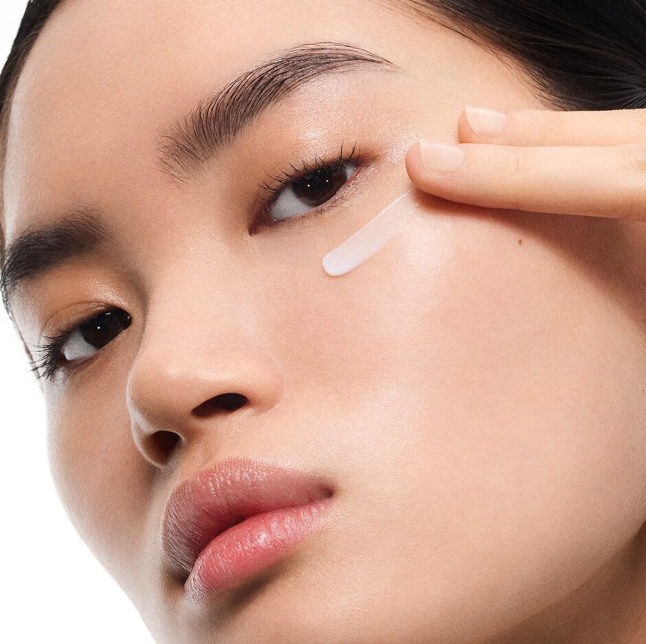 Das hellhäutige Model Mingma trägt die YSL Pure Shots Eye Reboot Cream unter dem Auge auf und präsentiert deren zarte Textur.