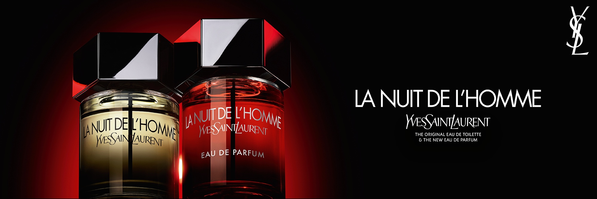 Eine dramatische Aufnahme der Flakons von La Nuit de l’Homme Eau de Toilette und Eau de Parfum nebeneinander, die den klassischen bernsteinfarbenen Inhalt dem neuen, intensiven roten Farbverlauf gegenüberstellt.