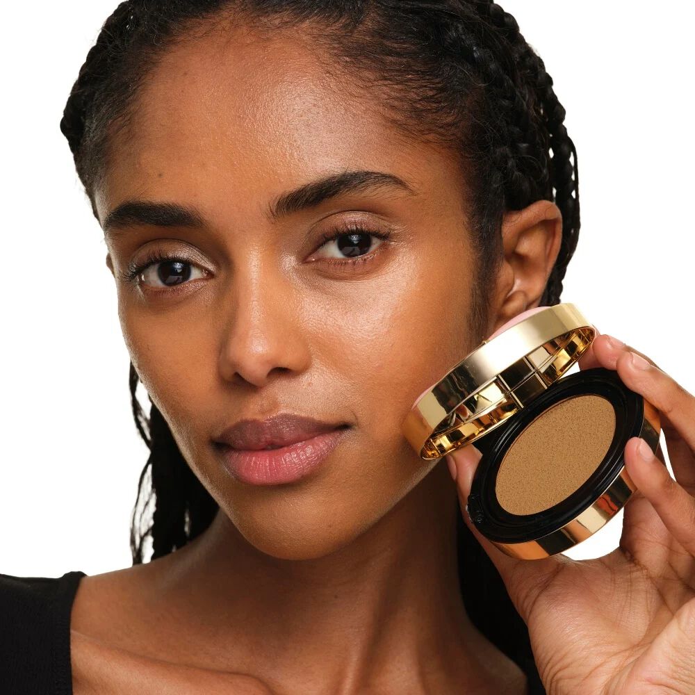 Model mit mittlerem Hautton, das YSL SKIN AFFAIR SOFT GLOW CUSHION hält. Strahlender, ebenmäßiger und natürlich wirkender Teint.