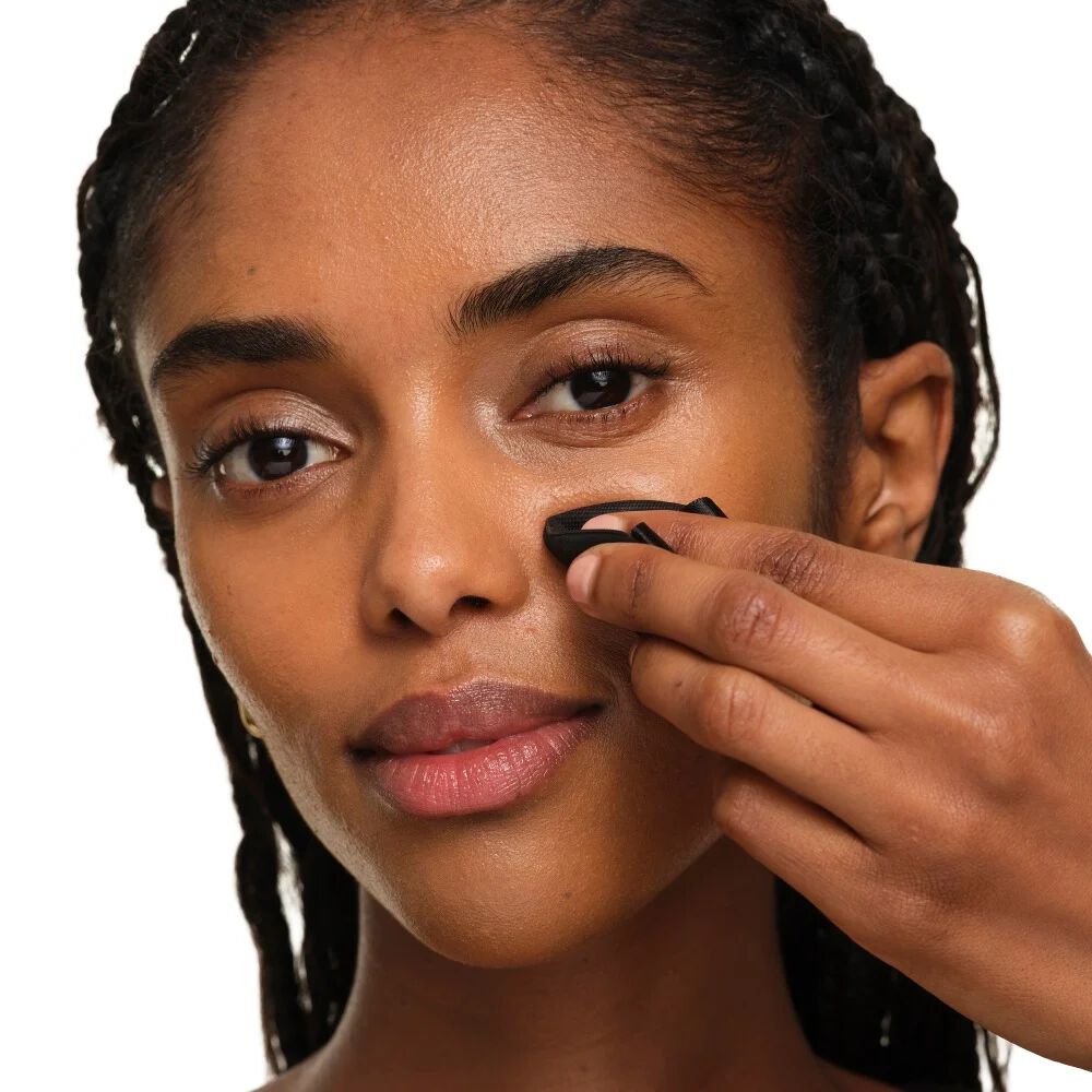 Nahaufnahme zeigt, wie man das YSL Makeup-Schwämmchen faltet für gezielte Präzision und Touch-ups rund um Nase und Augen.