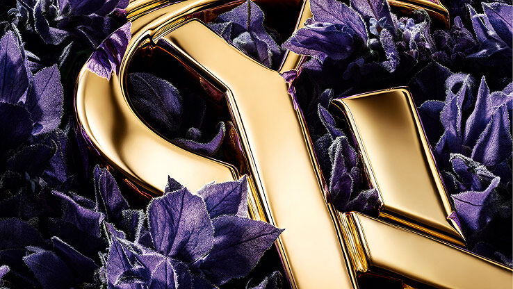 Prächtige violette Lavendelblüten heben die scharfen, goldenen Kanten des YSL-Logos hervor.
