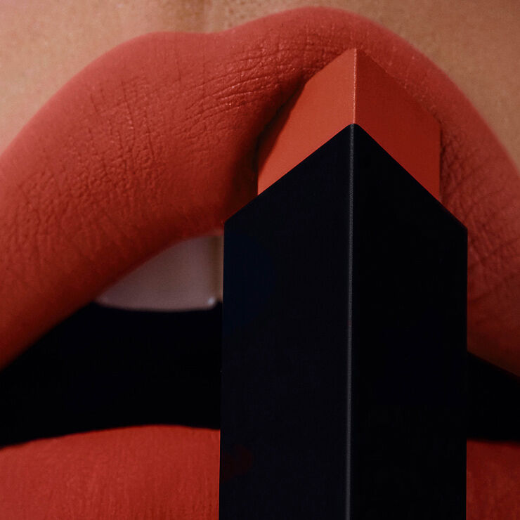 Schwarz-goldene YSL Hülle mit Cassandre-Logo vor goldenem Hintergrund.